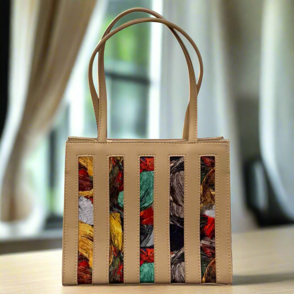 Beige handbag with colorful striped pattern on a blurred background