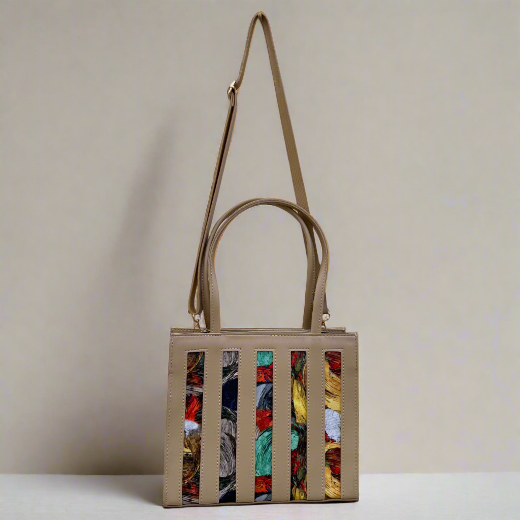 Handbag with colorful pattern on a wooden surface and white wall background